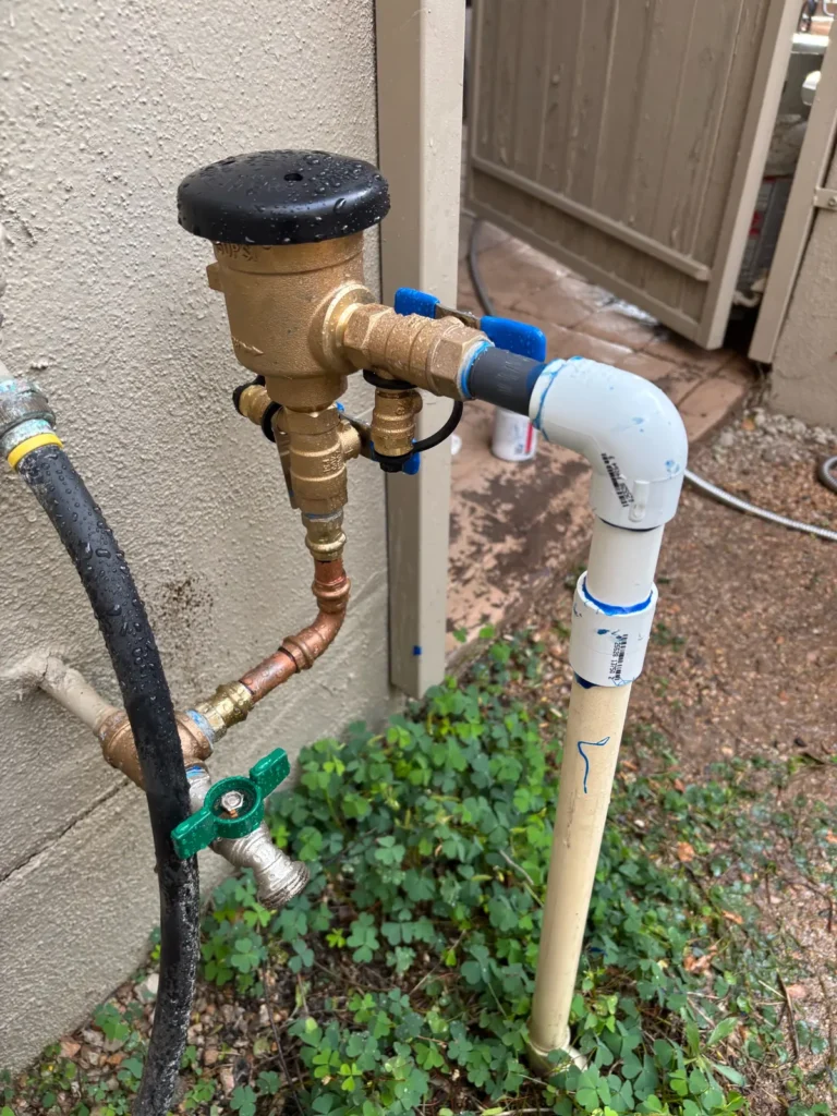 New brass irrigation backflow preventer installed with ball valve