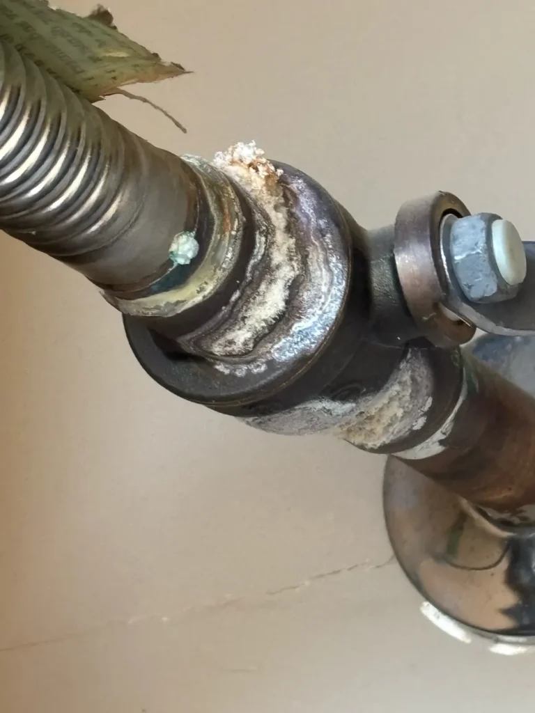 Corroded, mineral-crusted plumbing fitting found during an inspection