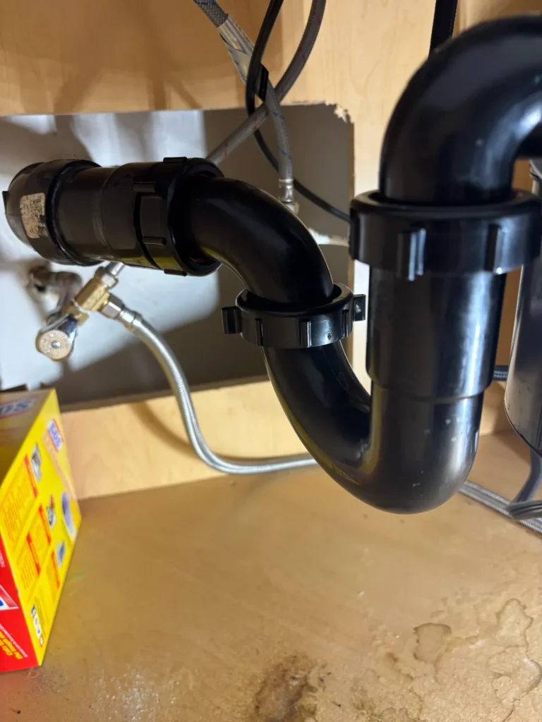 New kitchen sink drain trap installed with clean, tight joints